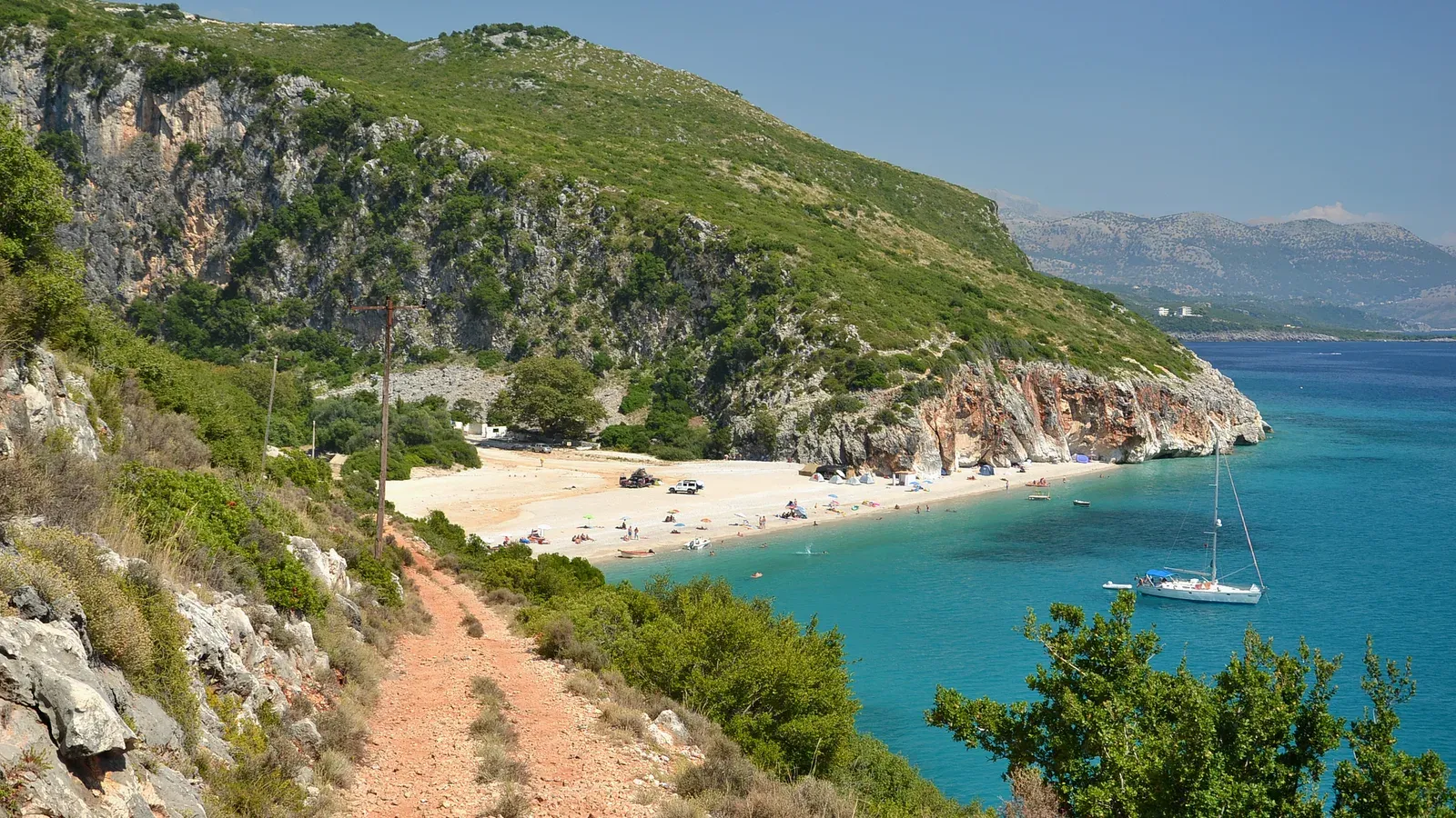 Gjipe Beach, a sandy cove with turquoise water below limestone cliffs on the Albanian Riviera